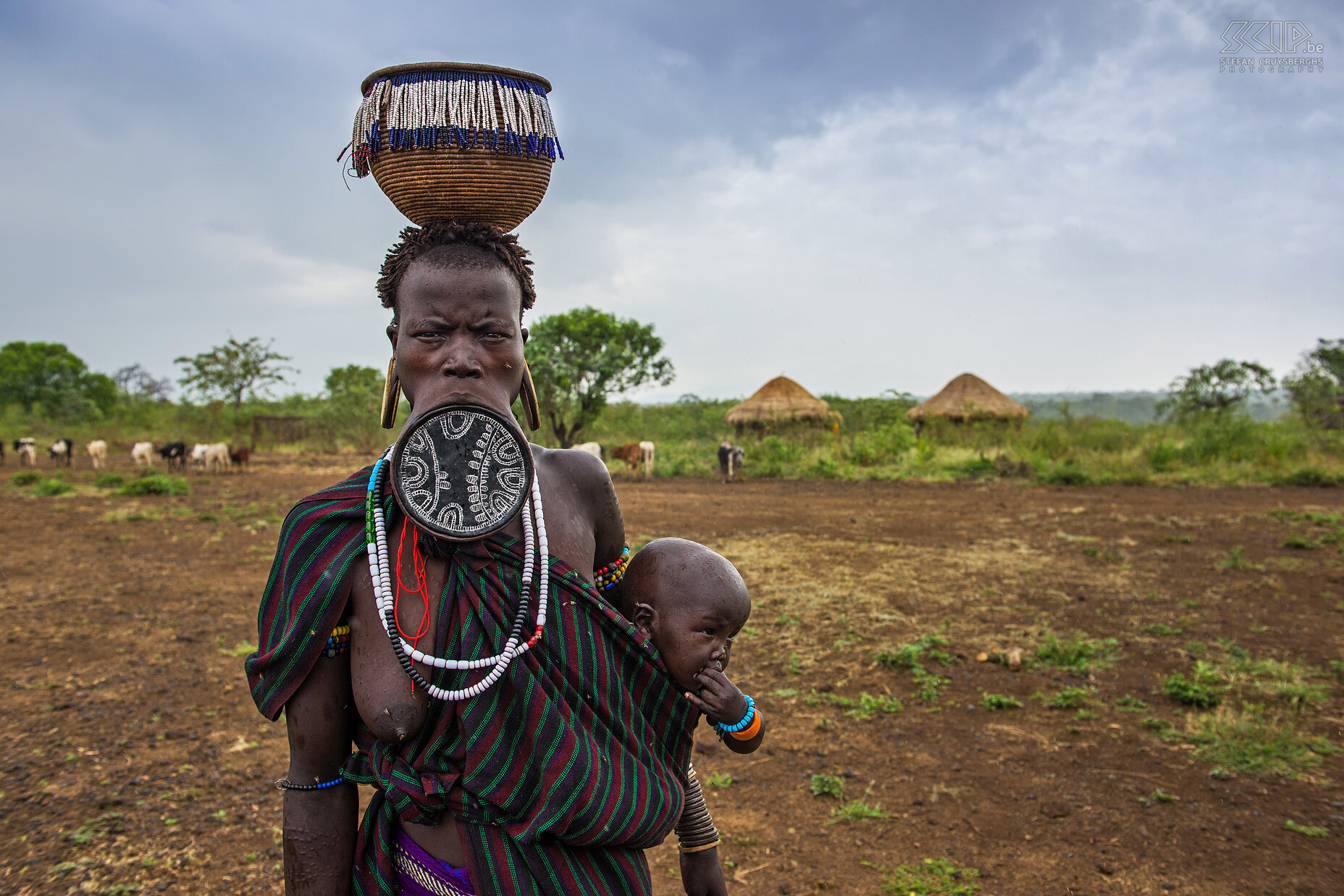 Mago - Mursi woman with lip plate and baby The lip plate is only worn by women and it is made from clay and inserted into a pierced hole in the lower lip. This woman is wearing an impressive lip plate, big disks in her ears, figurative incisions on her body and her baby wrapped in a cloth. Stefan Cruysberghs